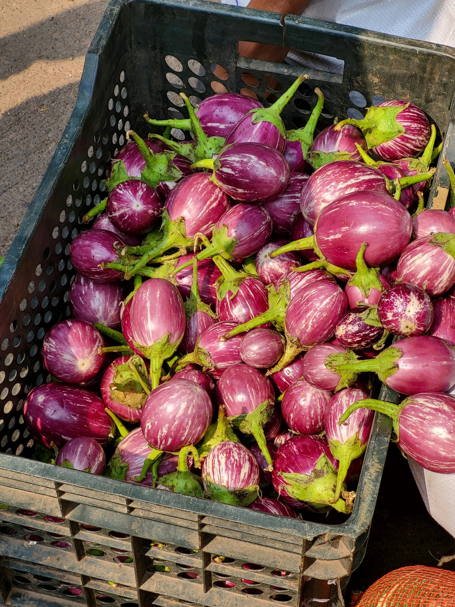 pexels photo 34346365 34346365 A basket filled with purple eggplants on display at an outdoor market.
