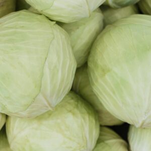 A close-up image of fresh green cabbage heads, showcasing their texture and color.