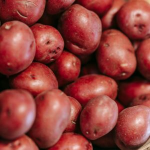 From above of fresh raw red potatoes in straw basket in local grocery market